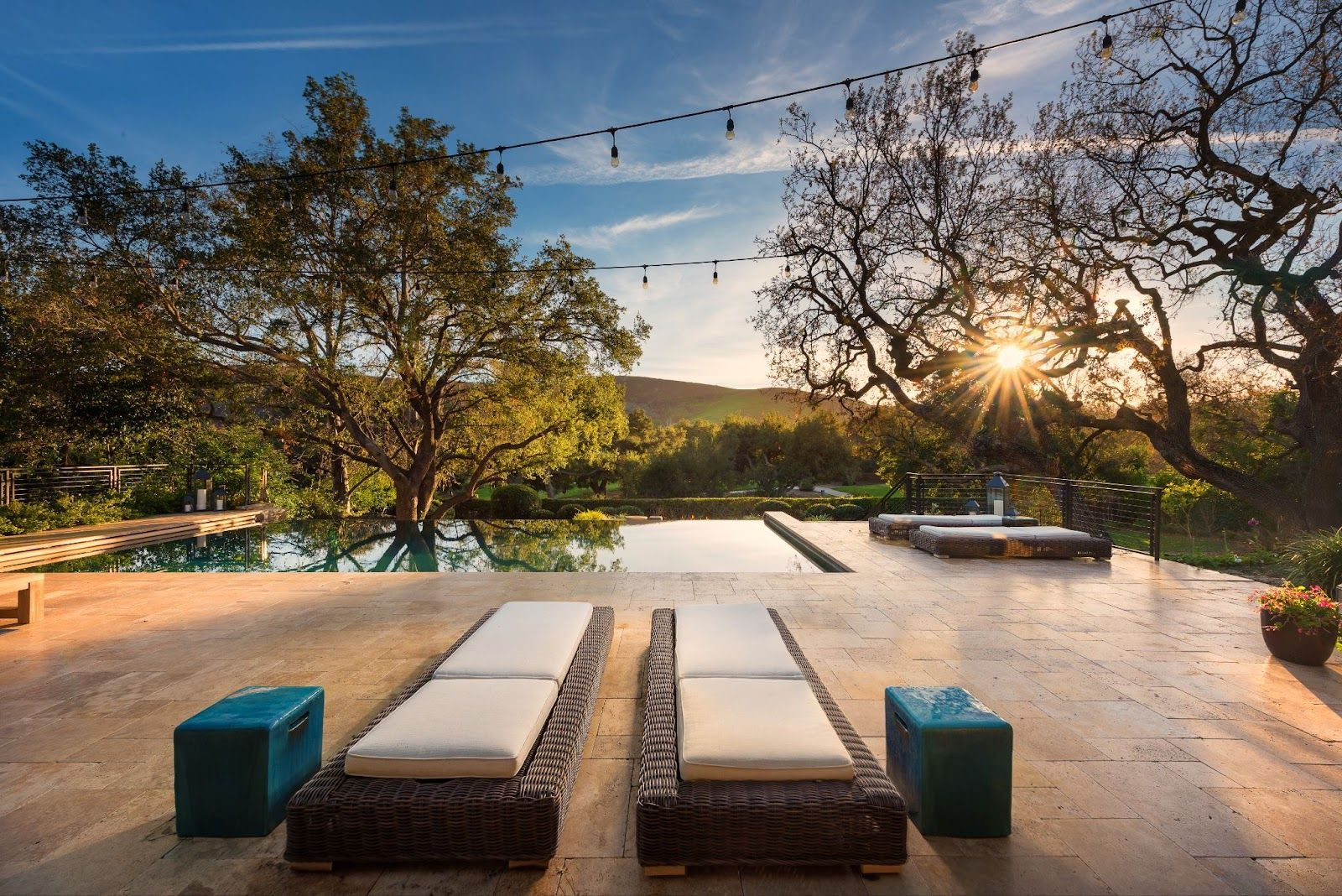 Fluidity pool design with sunset view and lounge deck chairs